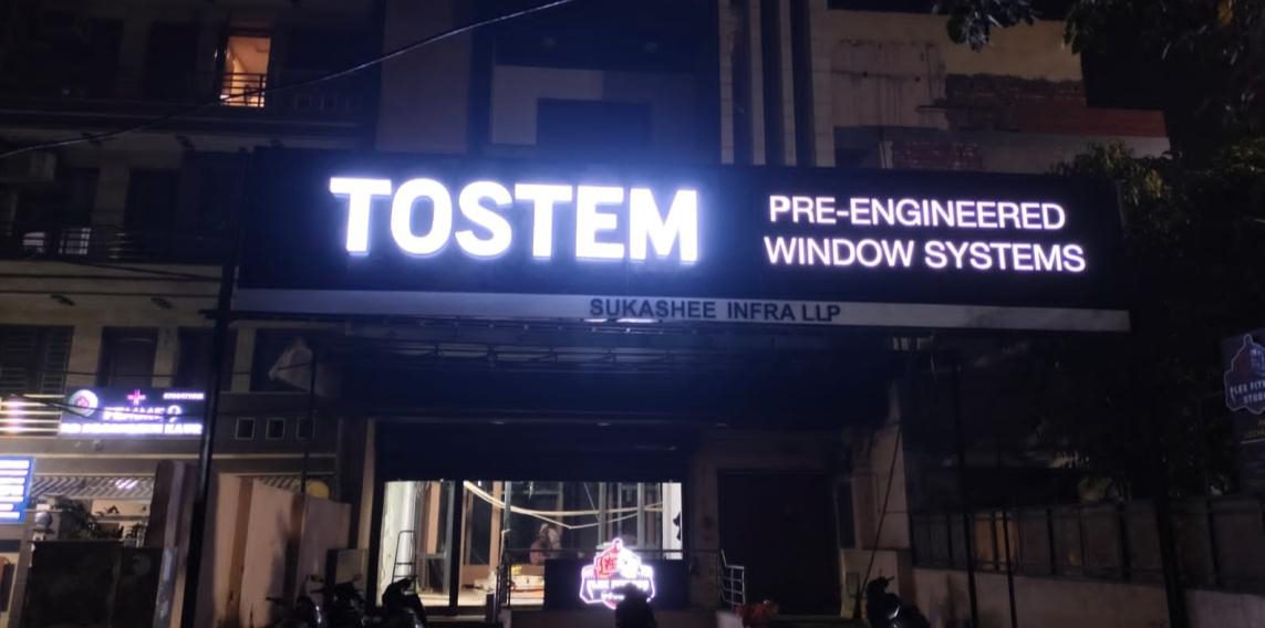 TOSTEM Pre-Engineered Window Systems illuminated fascia sign on a street-facing showroom