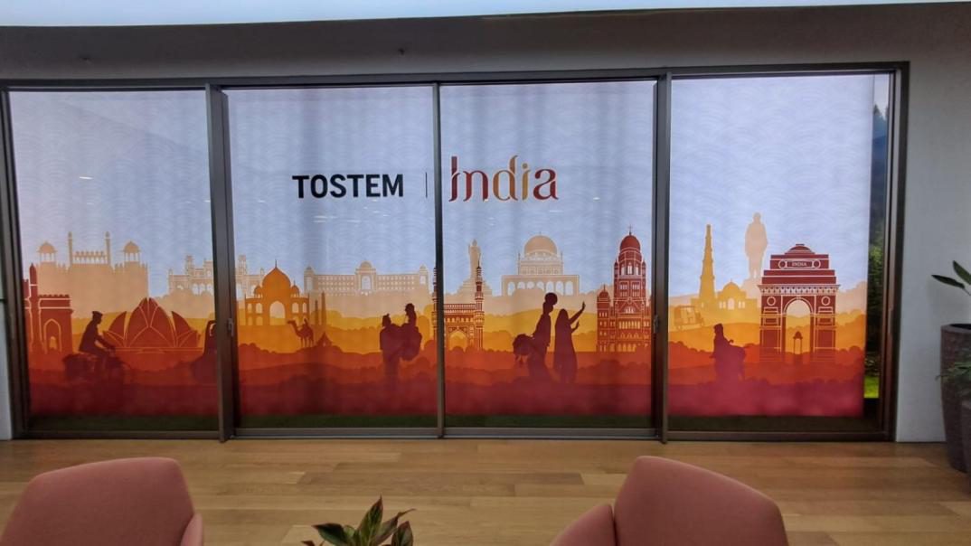 Backlit TOSTEM India mural with Indian landmark silhouettes across glass sliding doors