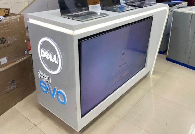 Dell and Intel Evo branded display counter with laptops on top and a front screen